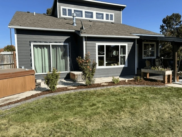 Landscape bed beside a green lawn and dark house